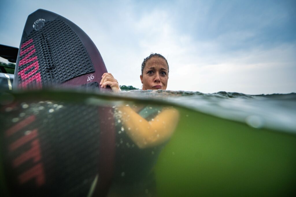Young woman enjoying summer water sports at the lake with her favorite wakeboard.