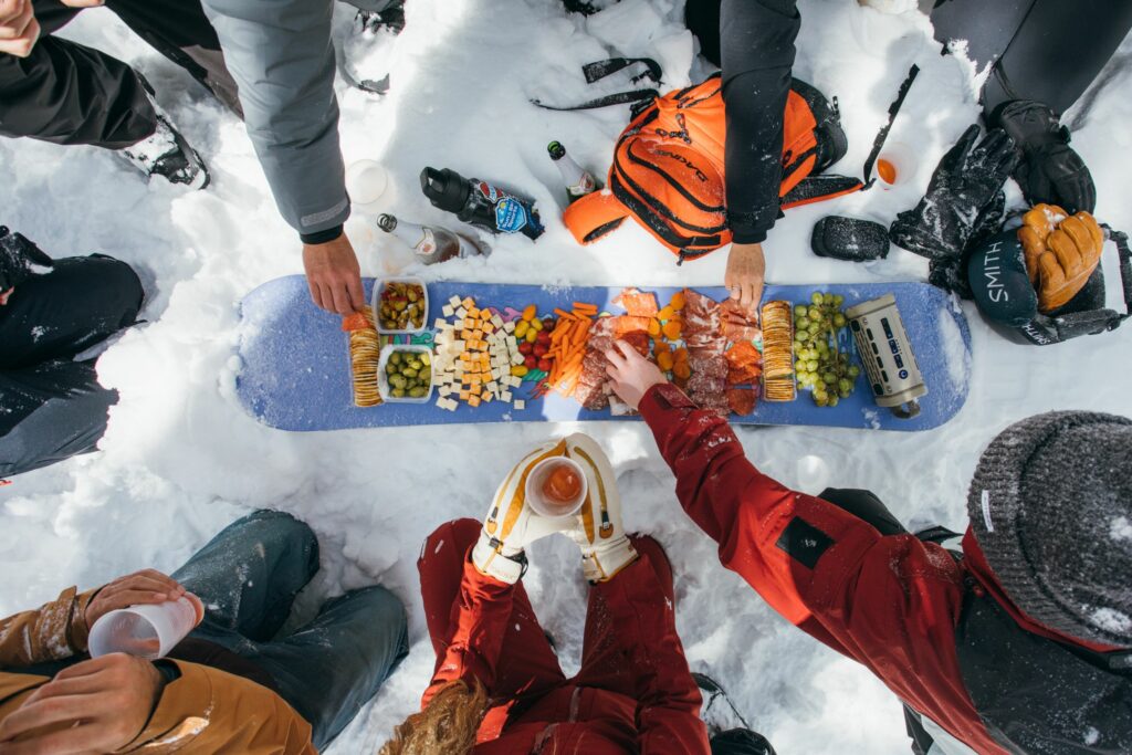 Snowboard charcuterie board filled with salami, cheese, and grapes at Sun & Ski Sports' ski camp!